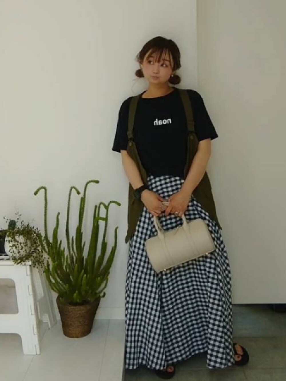 グリーン系のベスト、ブルー系のTシャツ/カットソー、ホワイト系のショルダーバッグを着用したレディースの夏コーディネートの5枚目の写真