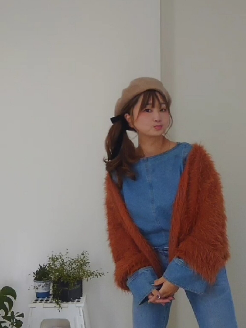 ブラウン系のカーディガン/ボレロ、ブルー系のシャツ/ブラウス、ブルー系のデニムパンツを着用したレディースの冬コーディネートの3枚目の写真