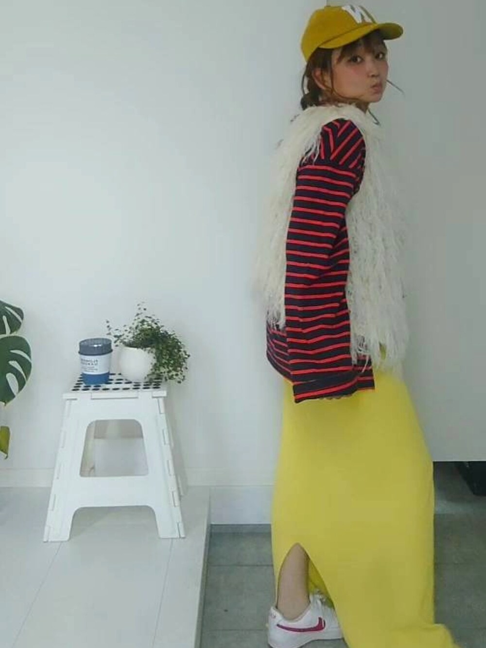 ブルー系のTシャツ/カットソー、イエロー系のスカート、イエロー系のキャップを着用したレディースの秋コーディネートの2枚目の写真