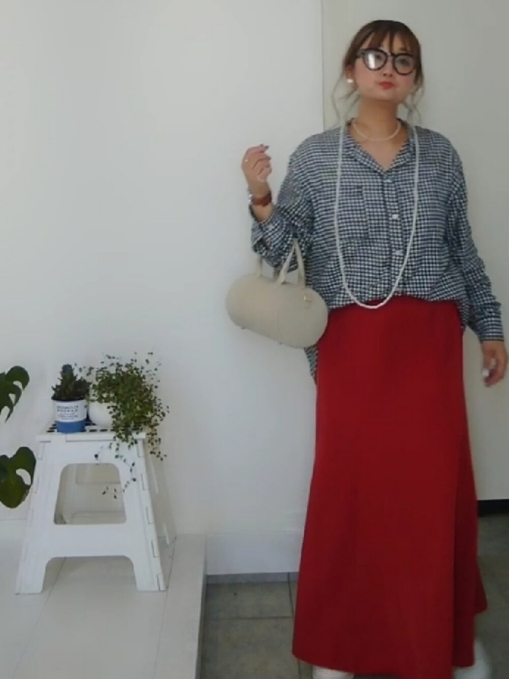 ブラック系のシャツ/ブラウス、オレンジ系のスカート、ホワイト系のショルダーバッグを着用したレディースの春コーディネートの3枚目の写真