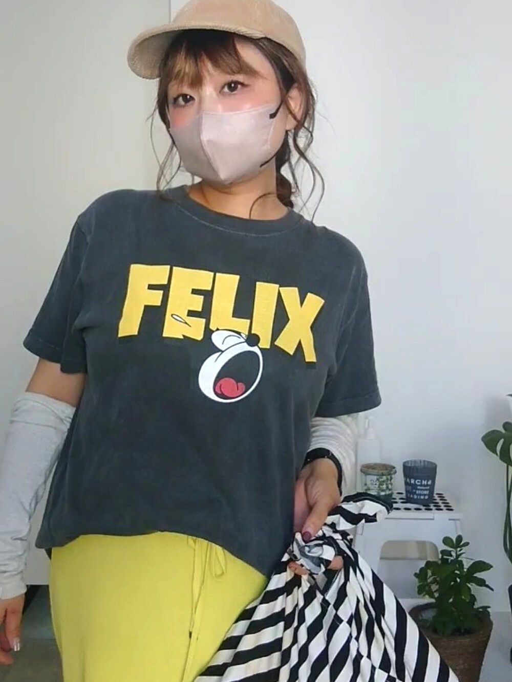 ブラック系のTシャツ/カットソー、イエロー系のスカート、ベージュ系のキャップを着用したレディースの秋コーディネートの3枚目の写真