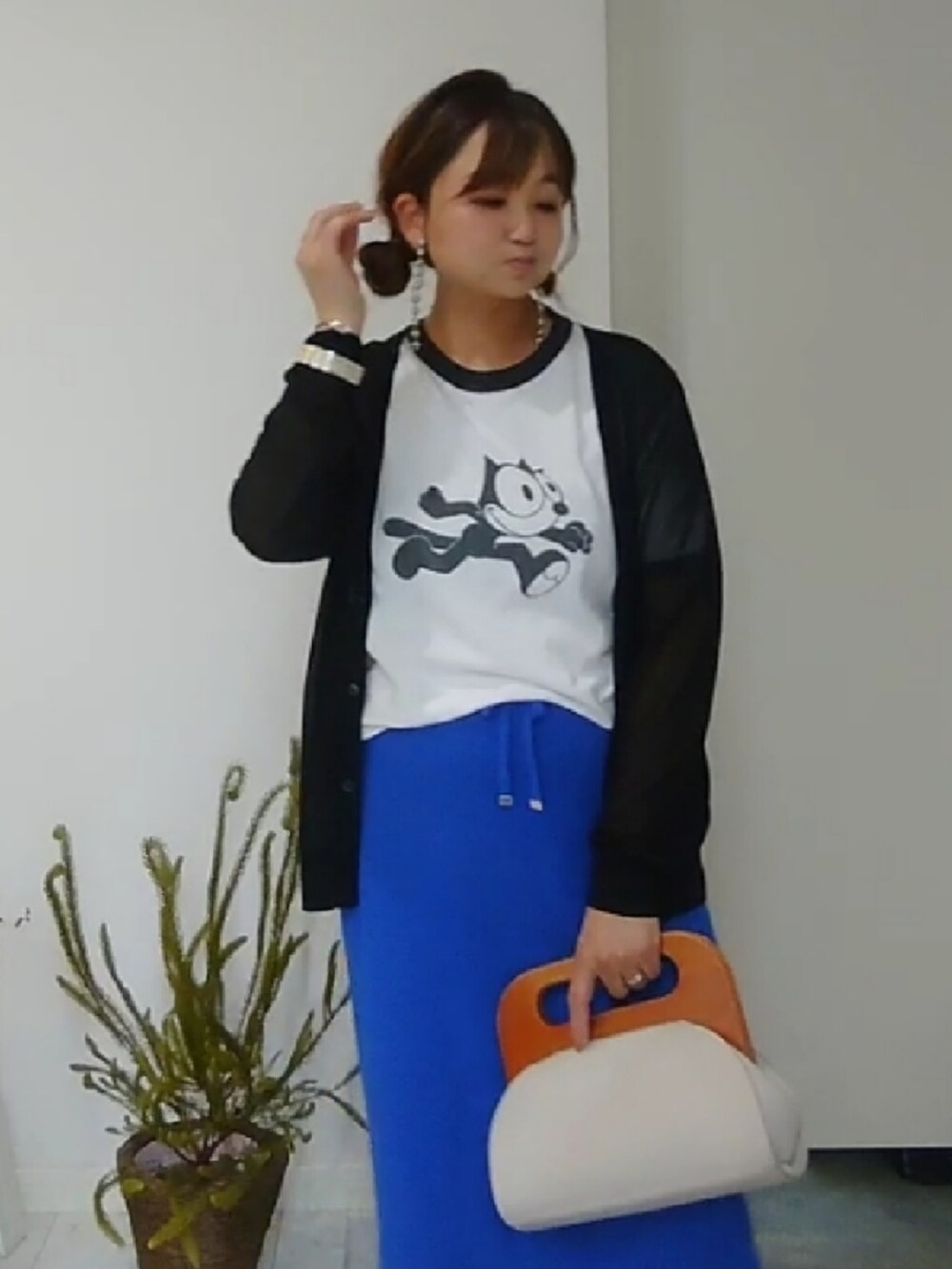 ホワイト系のクラッチバッグ、ブルー系のスカート、ブラック系のサンダルを着用したレディースの夏コーディネートの3枚目の写真