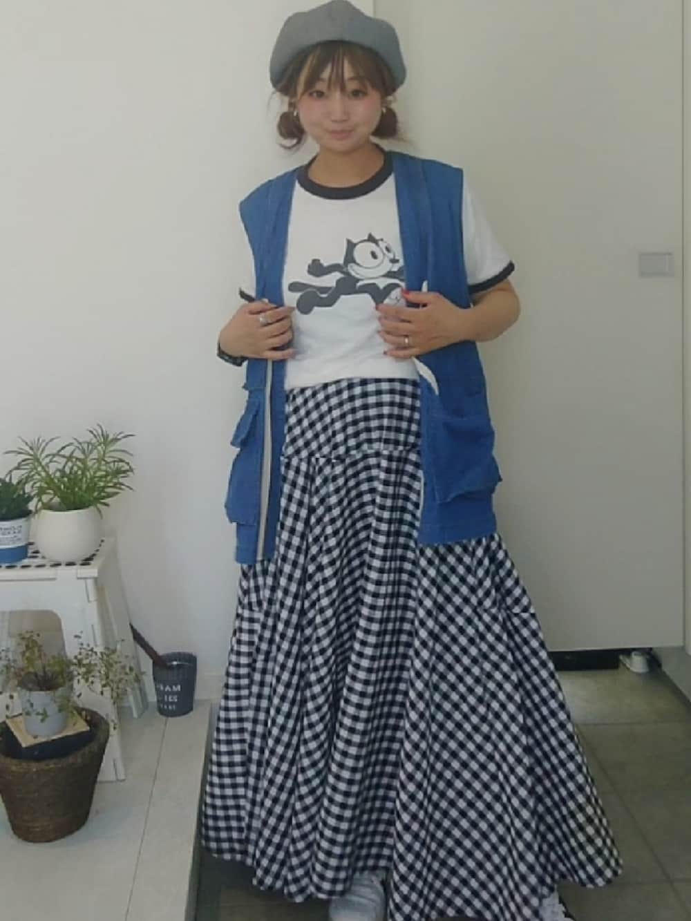 ホワイト系のTシャツ/カットソー、ブルー系のベスト、ブラック系のスカートを着用したレディースの秋コーディネートの3枚目の写真