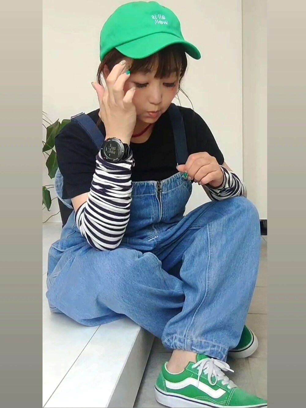 ブルー系のサロペット/オーバーオール、グリーン系のスニーカー、グリーン系のキャップを着用したレディースの夏コーディネートの2枚目の写真