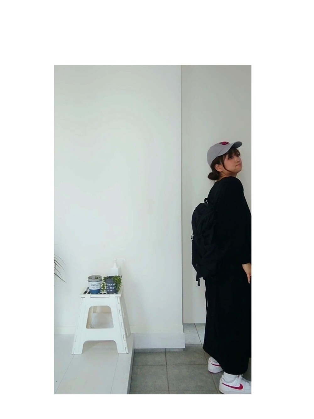 ブラック系のワンピース、レッド系のスニーカー、ブラック系のバックパック/リュックを着用したレディースの春コーディネートの3枚目の写真