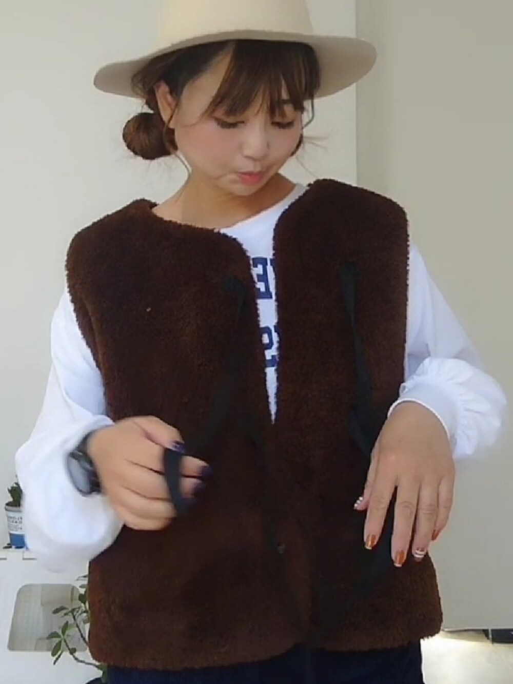 ホワイト系のTシャツ/カットソー、ブラウン系のベストを着用したレディースの秋コーディネートの3枚目の写真