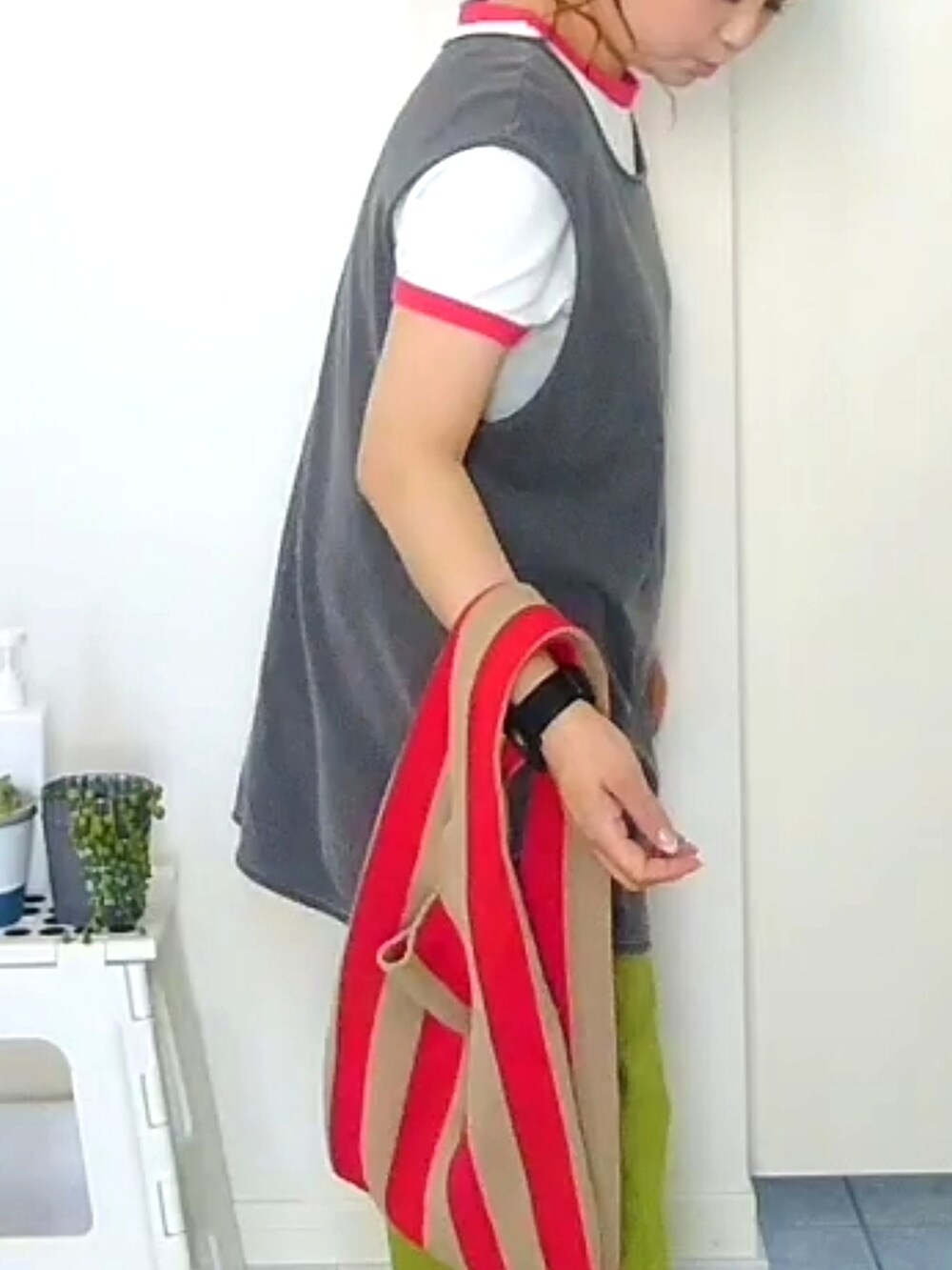 グリーン系のその他パンツ、グレー系のTシャツ/カットソー、レッド系のトートバッグを着用したレディースの春コーディネートの3枚目の写真