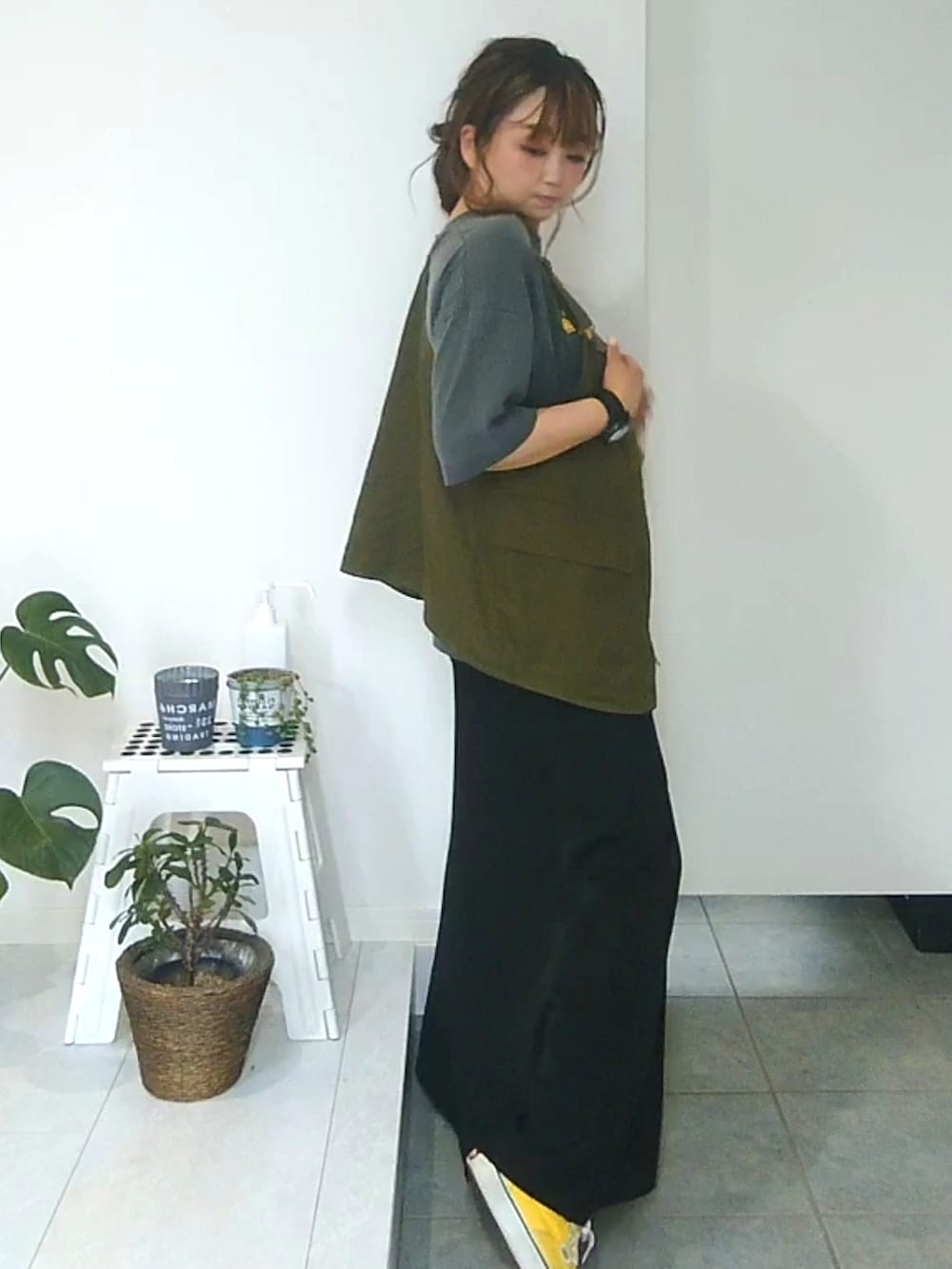 イエロー系のスニーカー、グリーン系のベストを着用したレディースの夏コーディネートの3枚目の写真