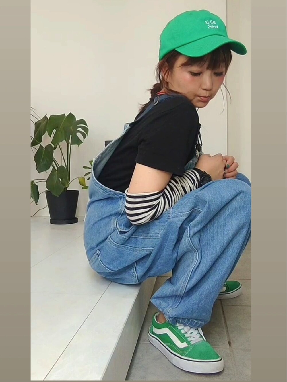 ブルー系のサロペット/オーバーオール、グリーン系のスニーカー、グリーン系のキャップを着用したレディースの夏コーディネートの3枚目の写真