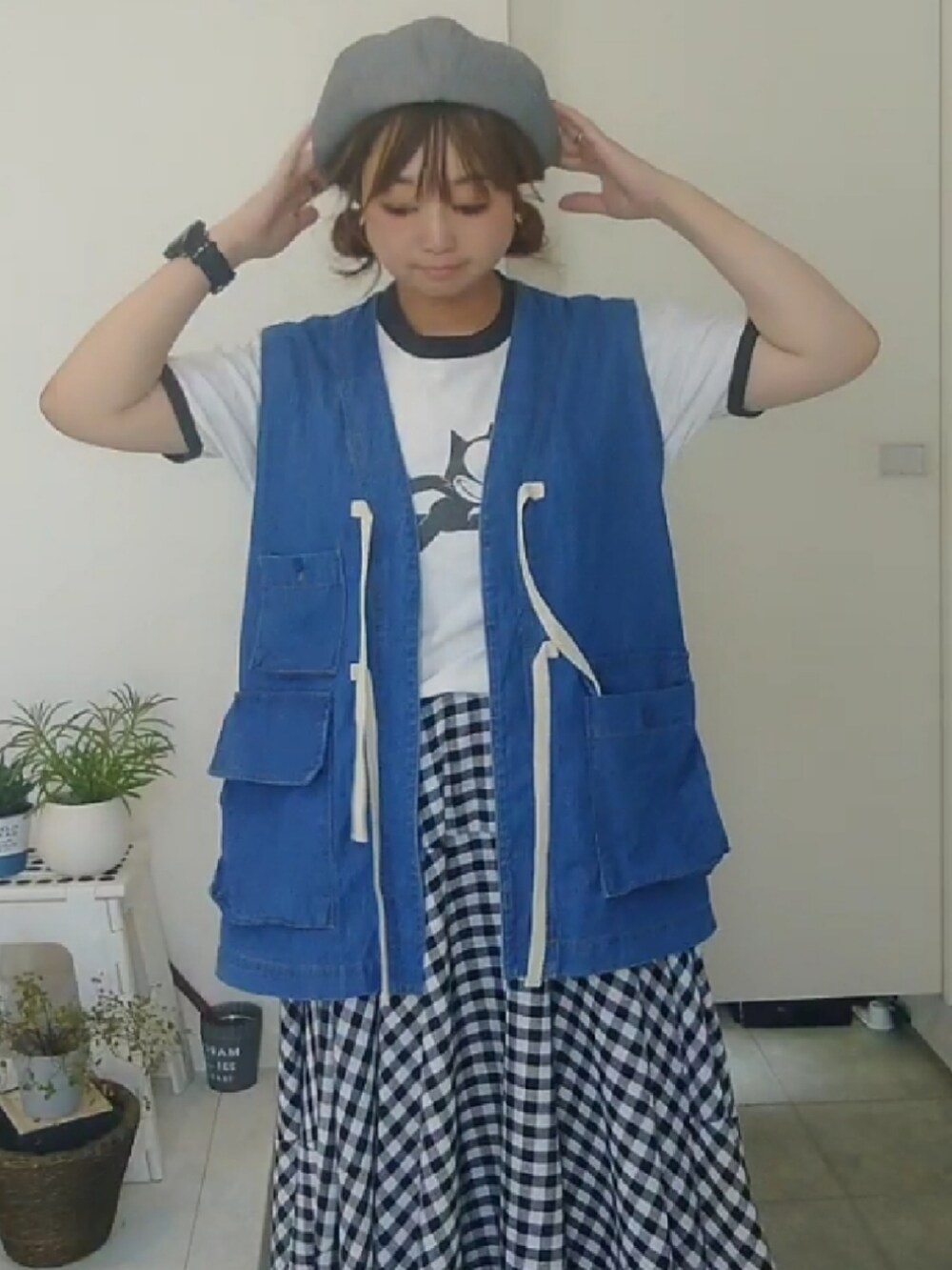 ホワイト系のTシャツ/カットソー、ブルー系のベスト、ブラック系のスカートを着用したレディースの秋コーディネートの2枚目の写真