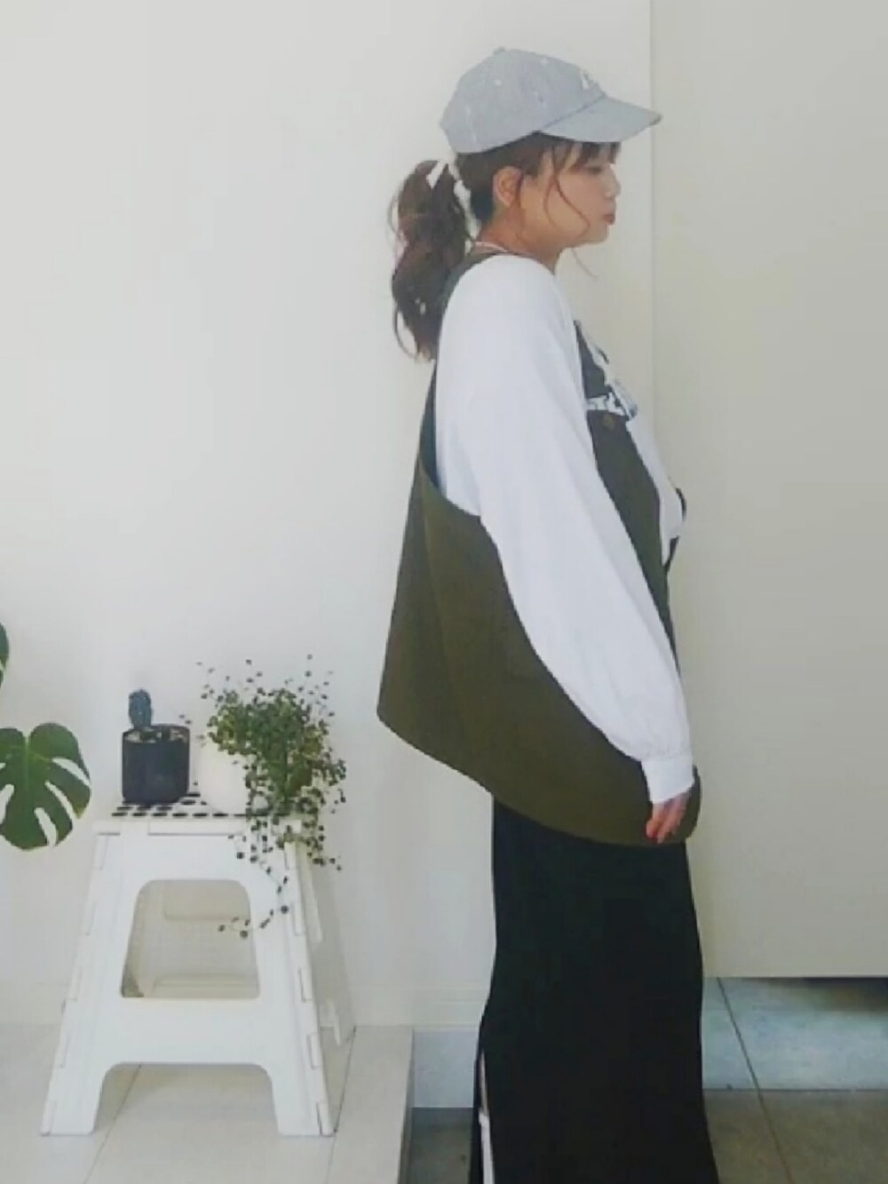 ホワイト系のTシャツ/カットソー、グリーン系のベスト、ブラック系のキャップを着用したレディースの春コーディネートの2枚目の写真