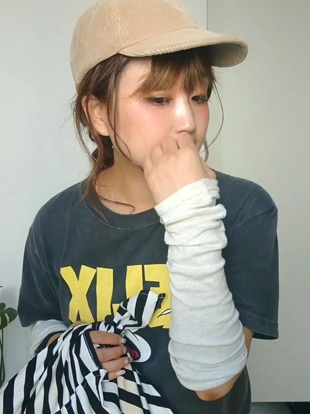 ブラック系のTシャツ/カットソー、イエロー系のスカート、ベージュ系のキャップを着用したレディースの秋コーディネートの2枚目の写真