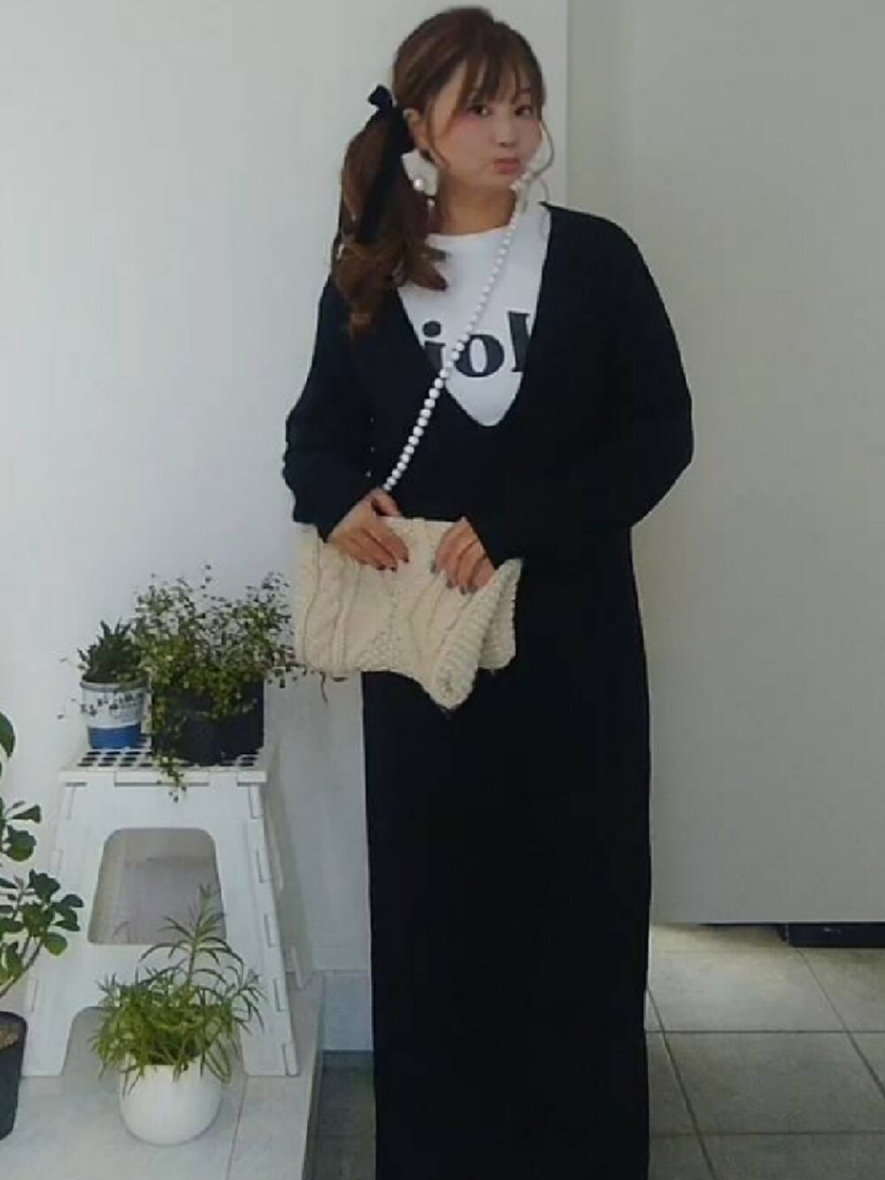 ブラック系のワンピース、ホワイト系のTシャツ/カットソー、ホワイト系のスマホグッズを着用したレディースの冬コーディネートの2枚目の写真