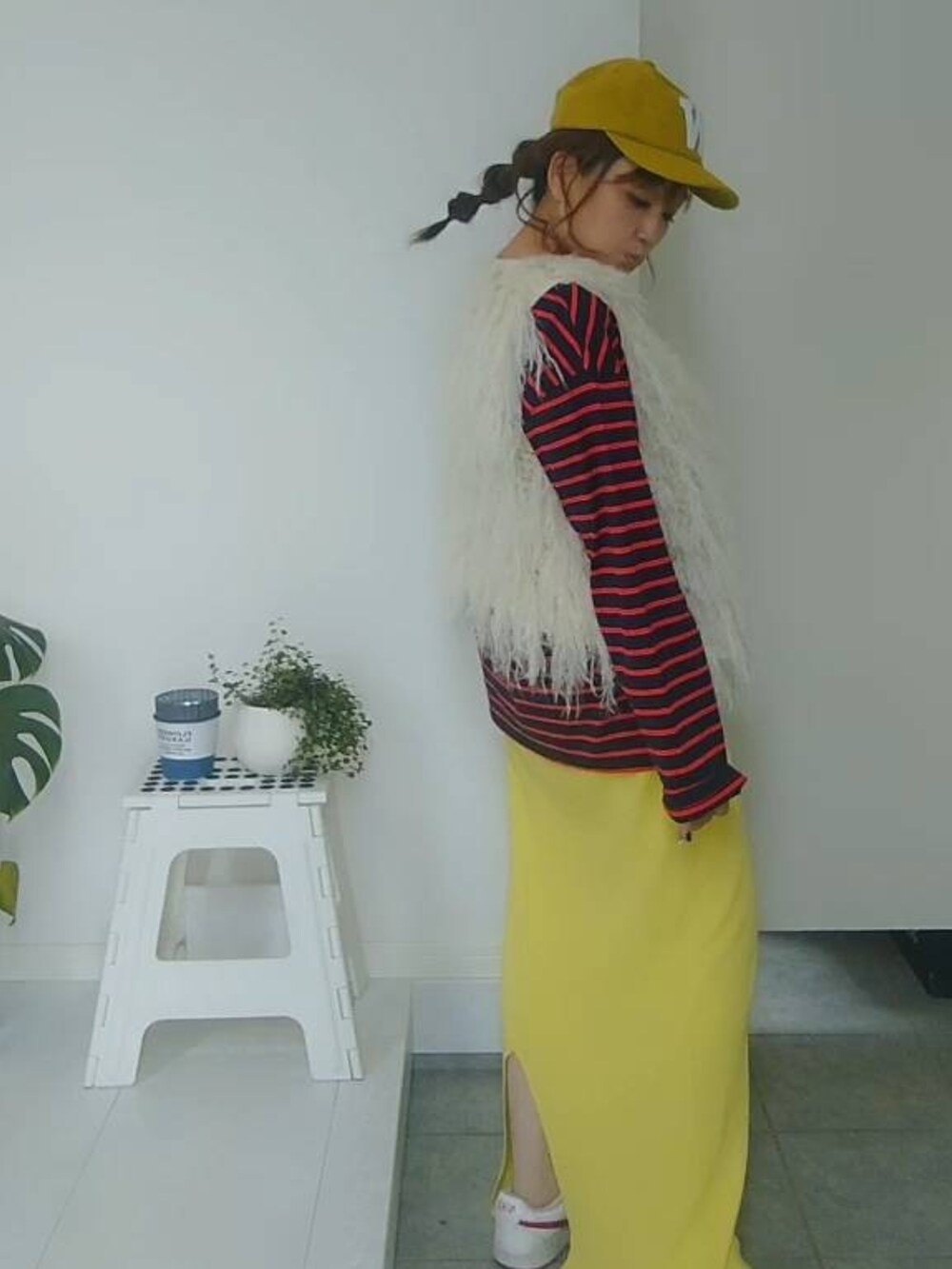 ブルー系のTシャツ/カットソー、イエロー系のスカート、イエロー系のキャップを着用したレディースの秋コーディネートの5枚目の写真