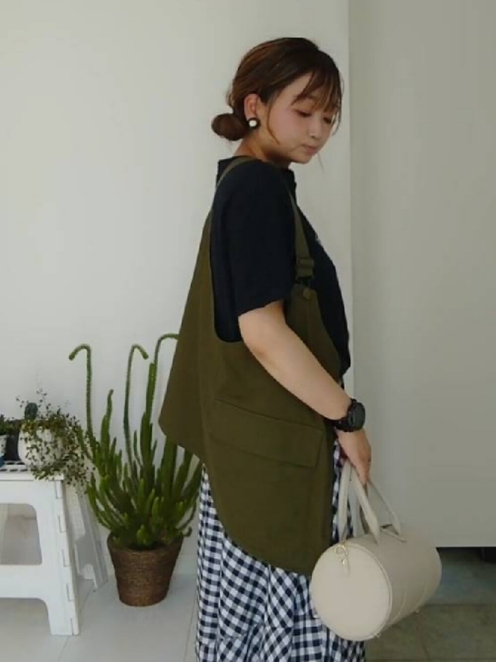 グリーン系のベスト、ブルー系のTシャツ/カットソー、ホワイト系のショルダーバッグを着用したレディースの夏コーディネートの4枚目の写真