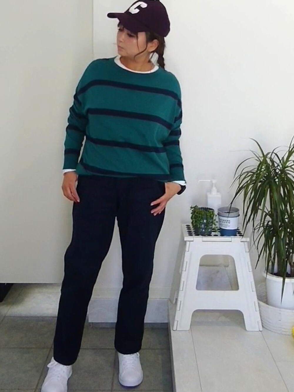 グリーン系のTシャツ/カットソー、ホワイト系のクラッチバッグ、ホワイト系のスニーカーを着用したレディースの春コーディネートの2枚目の写真