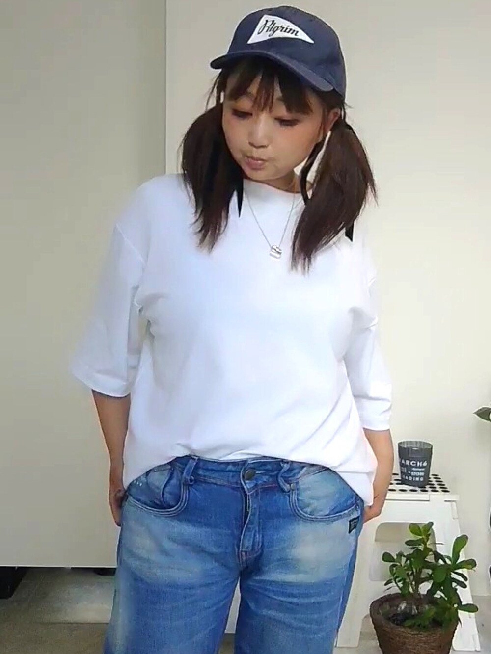 ブルー系のデニムパンツ、ブラック系のスニーカー、ブルー系のキャップを着用したレディースの夏コーディネートの3枚目の写真