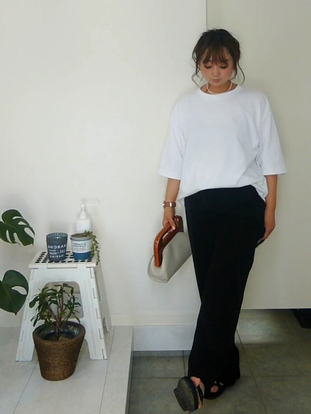 ブラック系のその他パンツ、ブラック系のサンダル、ホワイト系のクラッチバッグを着用したレディースの夏コーディネートの2枚目の写真
