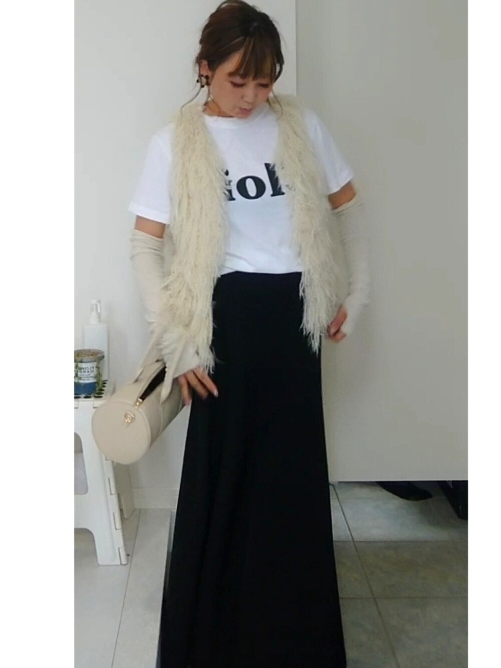 ホワイト系のTシャツ/カットソー、ブラック系のスカート、ホワイト系のショルダーバッグを着用したレディースの秋コーディネートの3枚目の写真