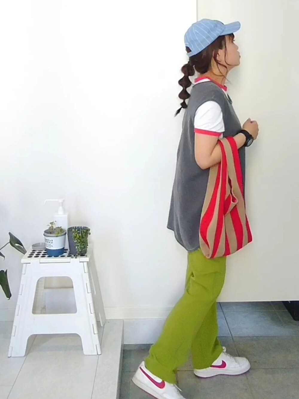 グリーン系のその他パンツ、グレー系のTシャツ/カットソー、レッド系のトートバッグを着用したレディースの春コーディネートの2枚目の写真