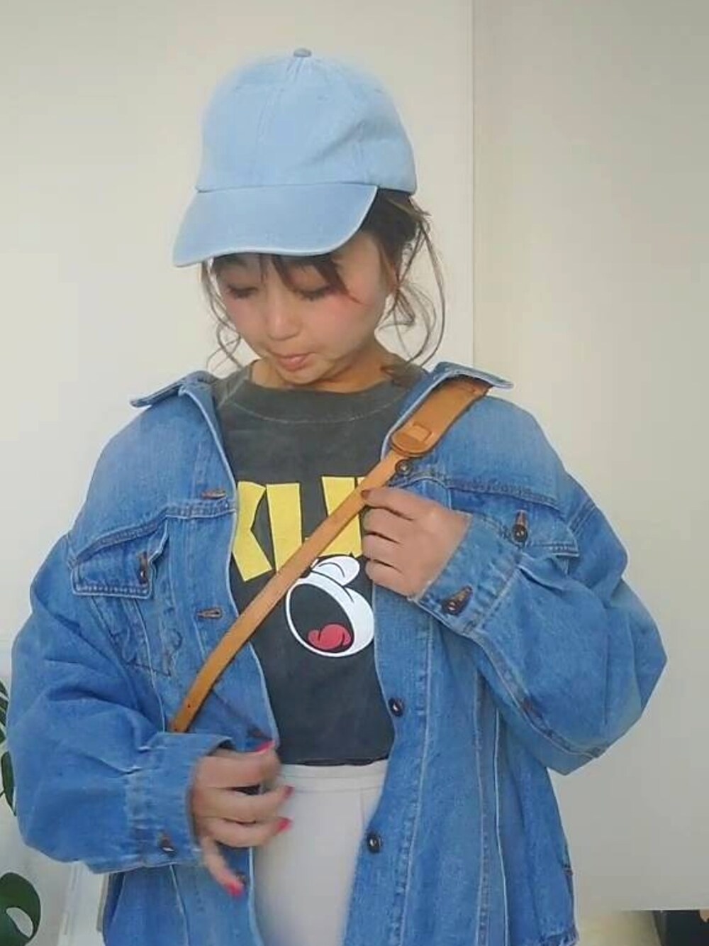 ブルー系のデニムジャケット、ブラック系のTシャツ/カットソー、ホワイト系のスラックスを着用したレディースの春コーディネートの3枚目の写真