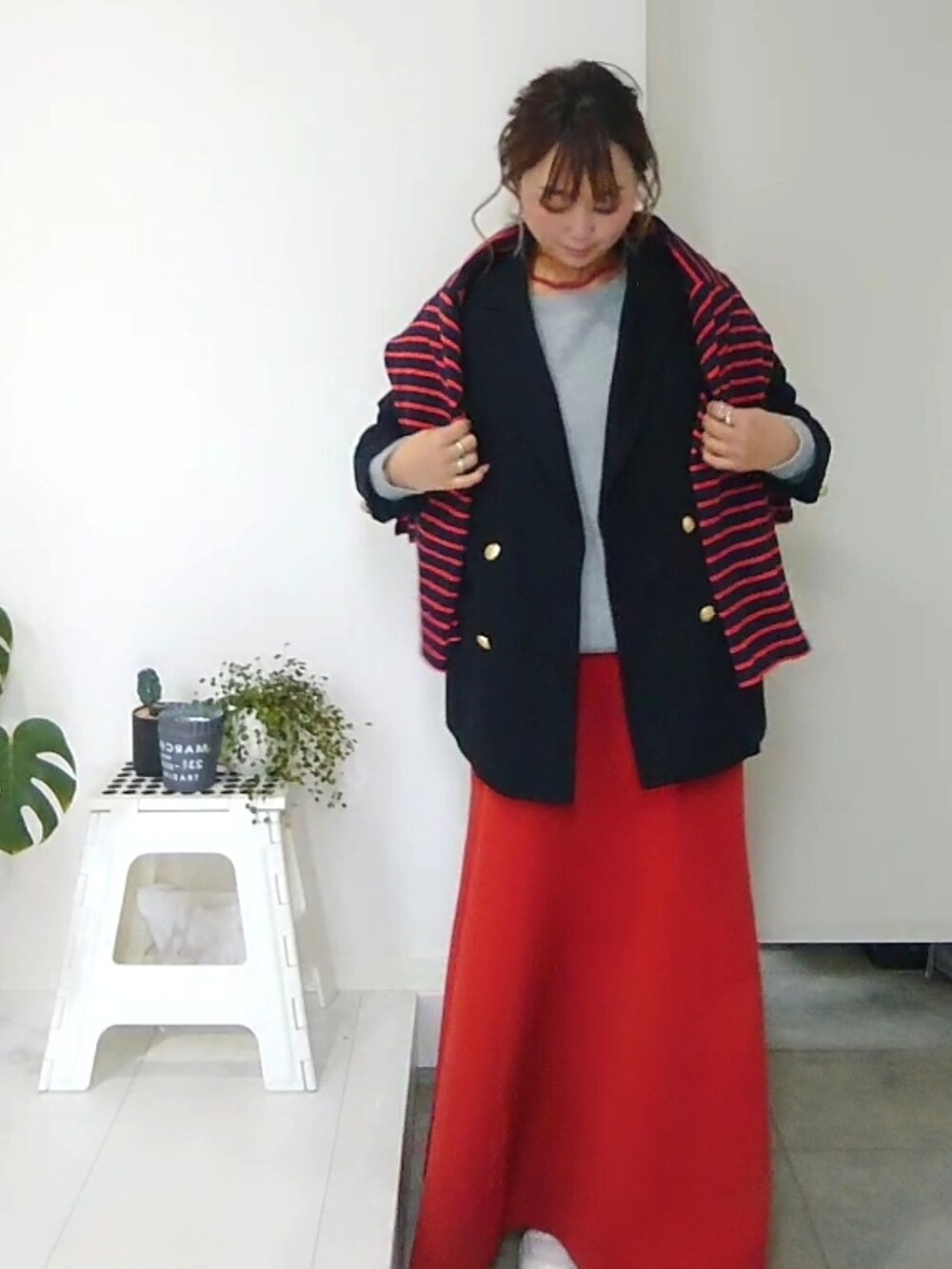 オレンジ系のスカート、ブルー系のテーラードジャケット、ブルー系のTシャツ/カットソーを着用したレディースの冬コーディネートの2枚目の写真