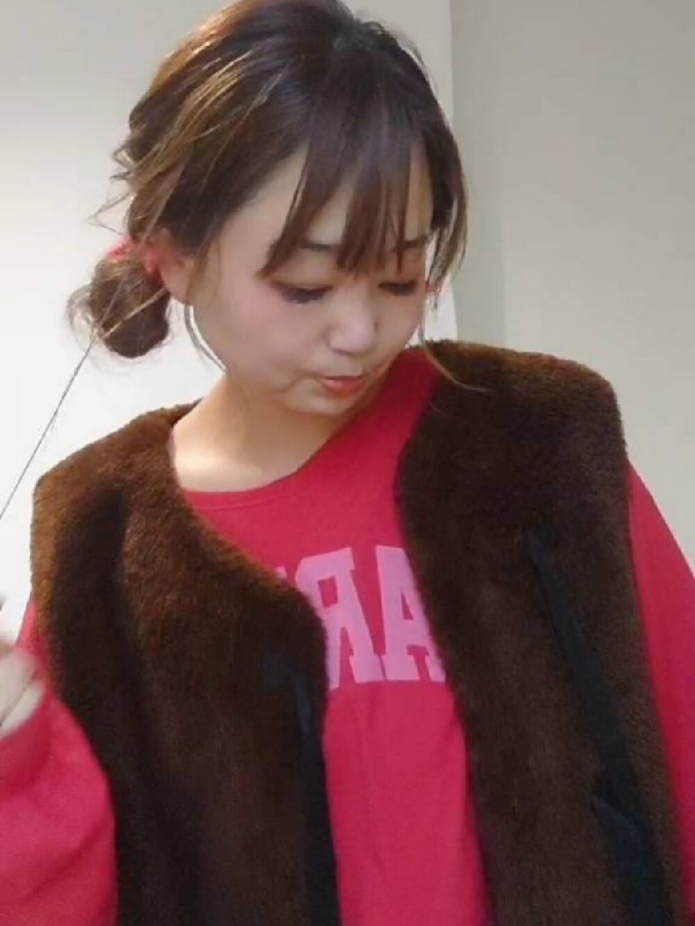 レッド系のTシャツ/カットソー、ブラウン系のベスト、ホワイト系のスカートを着用したレディースの秋コーディネートの2枚目の写真