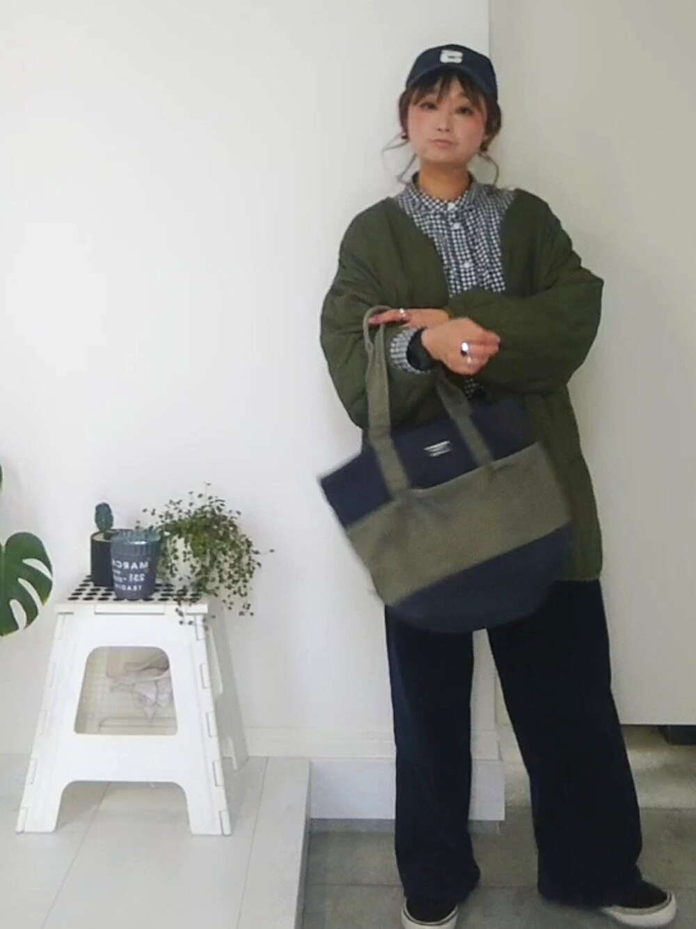 ブラック系のシャツ/ブラウス、ブラック系のスカート、ブルー系のキャップを着用したレディースの冬コーディネートの2枚目の写真