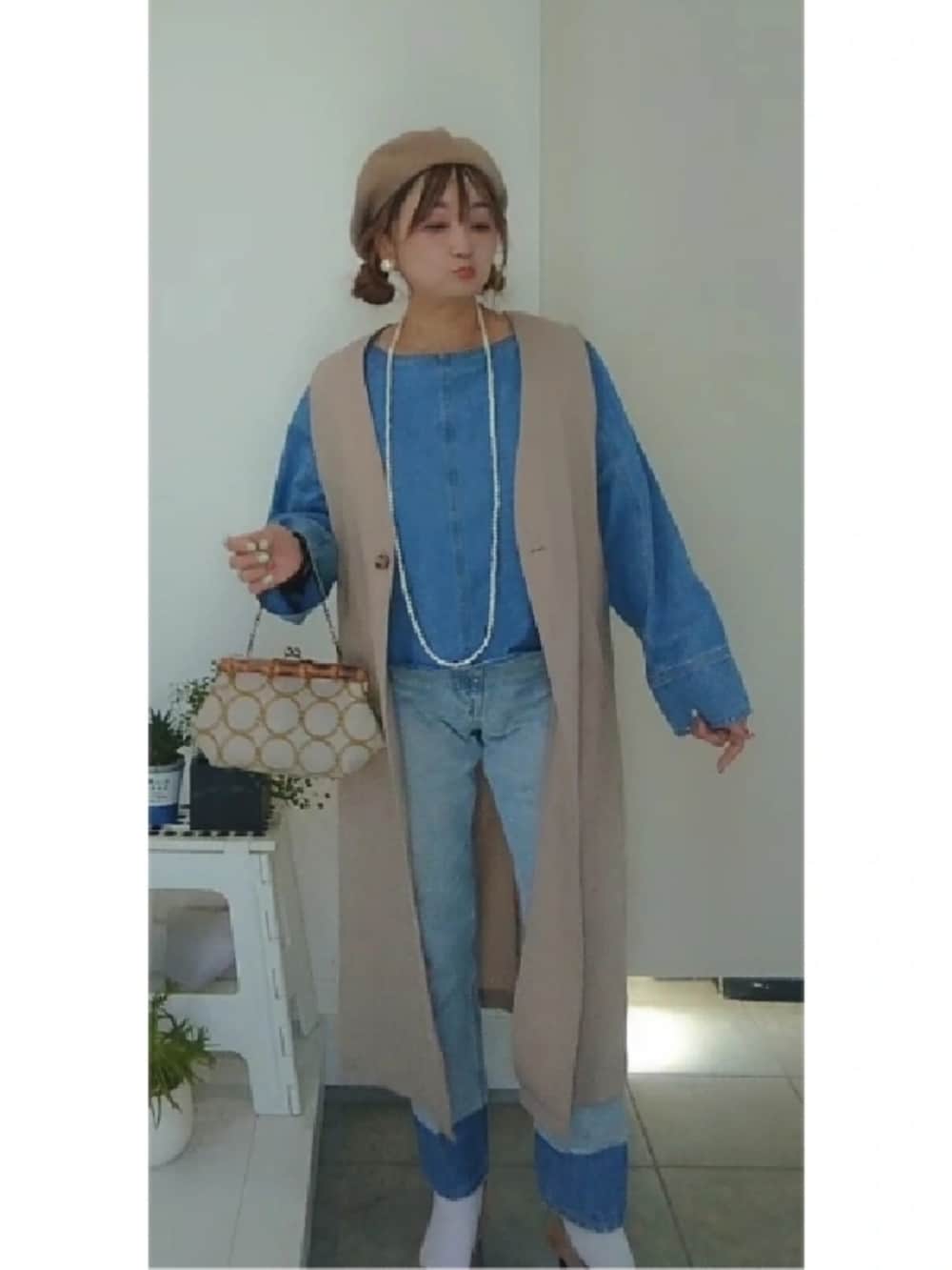 ブルー系のシャツ/ブラウス、ブルー系のデニムパンツ、ホワイト系のベストを着用したレディースの冬コーディネートの3枚目の写真