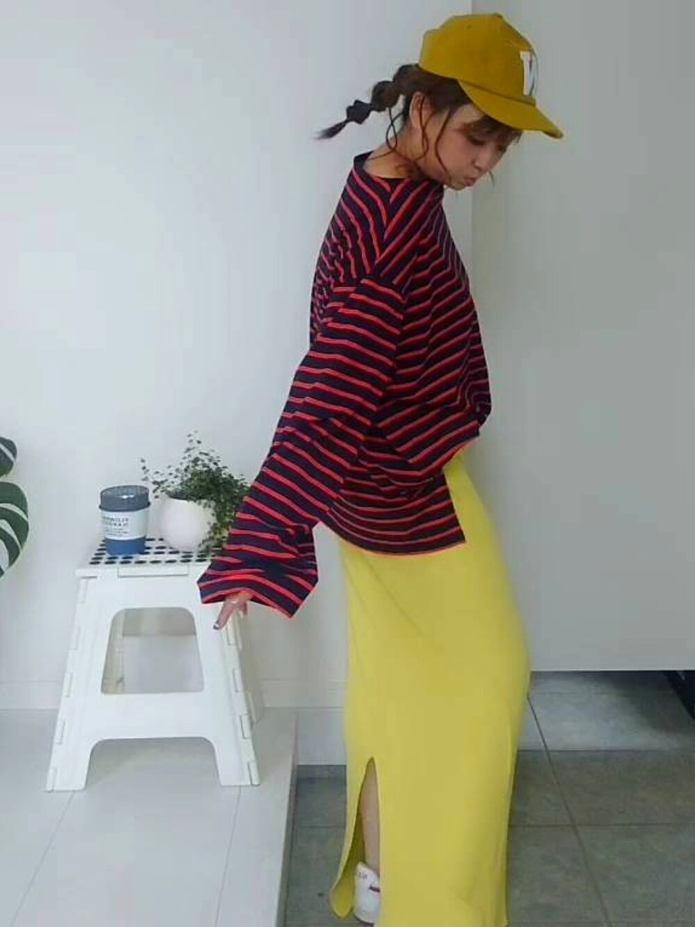 ブルー系のTシャツ/カットソー、イエロー系のスカート、イエロー系のキャップを着用したレディースの秋コーディネートの3枚目の写真