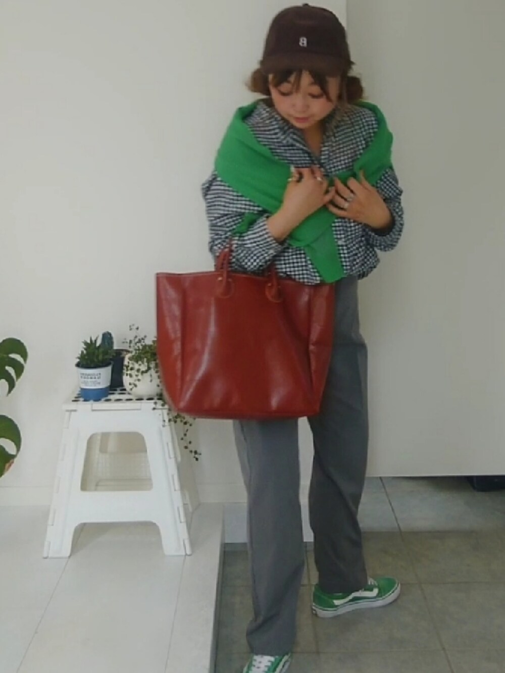 ブラック系のシャツ/ブラウス、ブラウン系のトートバッグ、グリーン系のスニーカーを着用したレディースの夏コーディネートの3枚目の写真