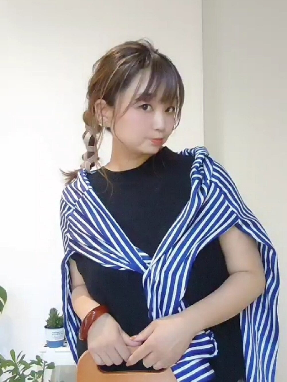 ブルー系のシャツ/ブラウス、ベージュ系のパンツ、ブラック系のニット/セーターを着用したレディースの夏コーディネートの2枚目の写真