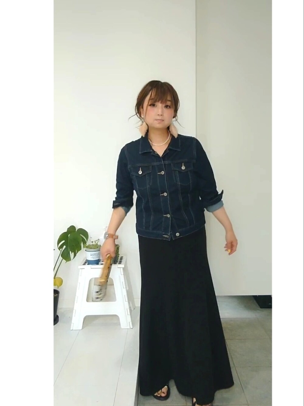 ブルー系のデニムジャケット、ブラック系のスカート、ホワイト系のサンダルを着用したレディースの春コーディネートの2枚目の写真