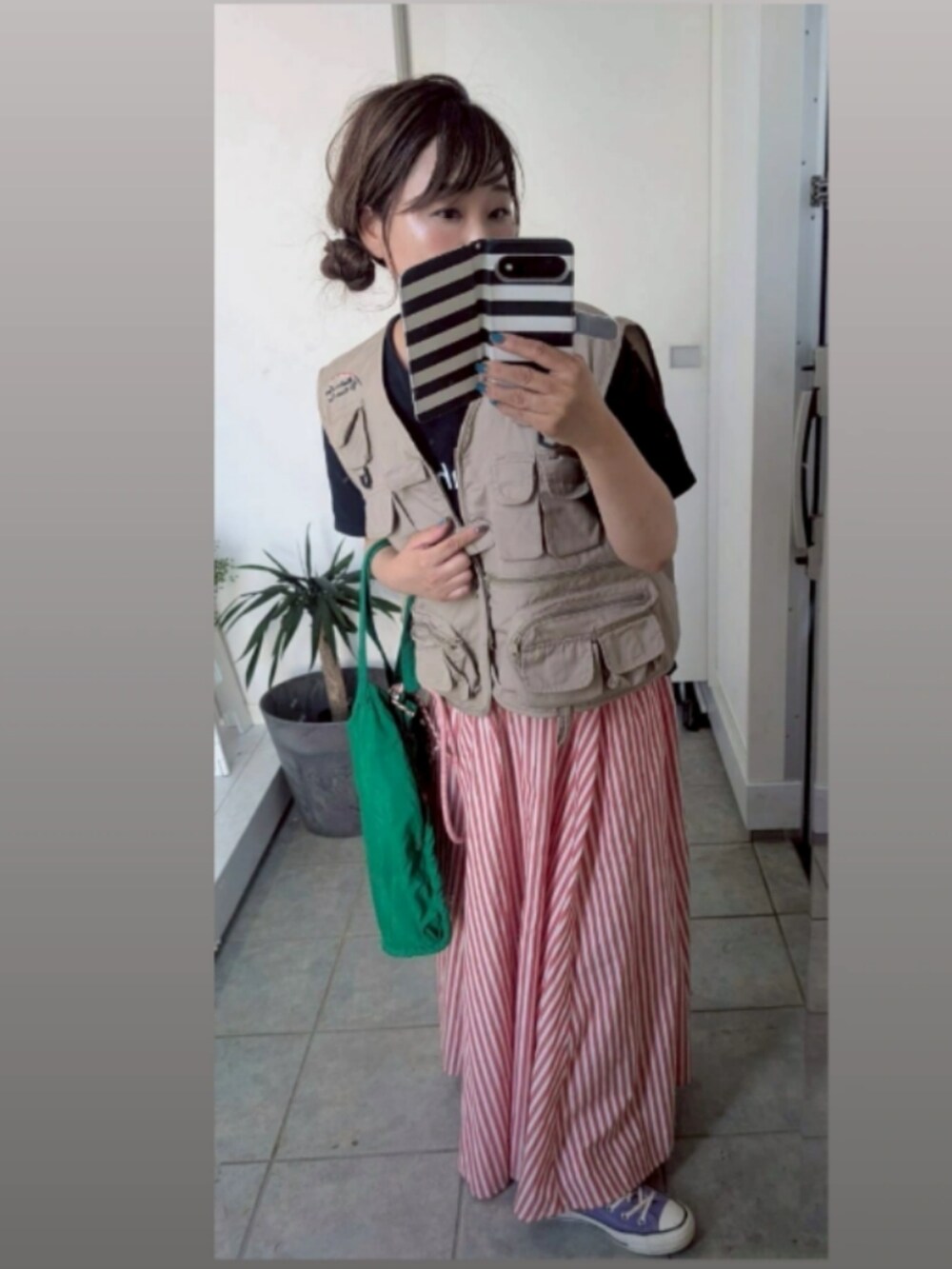 レッド系のスカートを着用したレディースの秋コーディネートの2枚目の写真