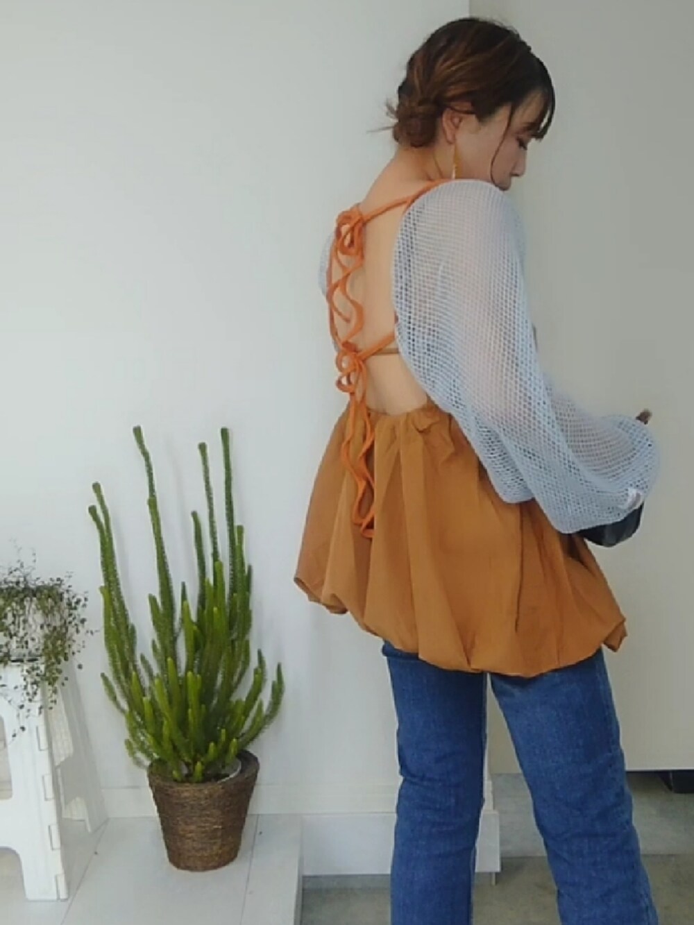 ブラック系のハンドバッグ、ブルー系のカーディガン/ボレロ、イエロー系のキャミソールを着用したレディースの夏コーディネートの2枚目の写真