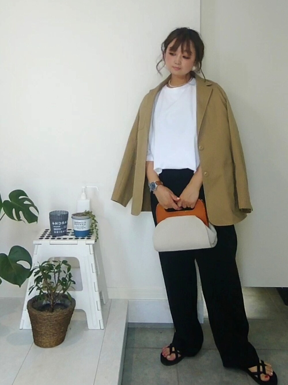 ブラック系のその他パンツ、ブラック系のサンダル、ホワイト系のクラッチバッグを着用したレディースの夏コーディネートの3枚目の写真