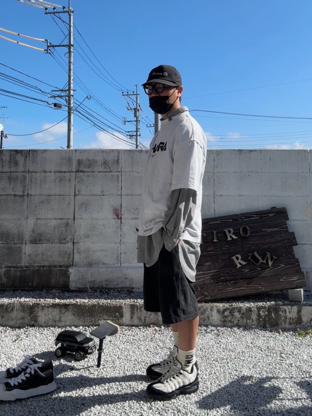 ブラック系のデニムパンツ、ホワイト系のTシャツ/カットソー、グレー系のスニーカーを着用したメンズの春コーディネートの2枚目の写真