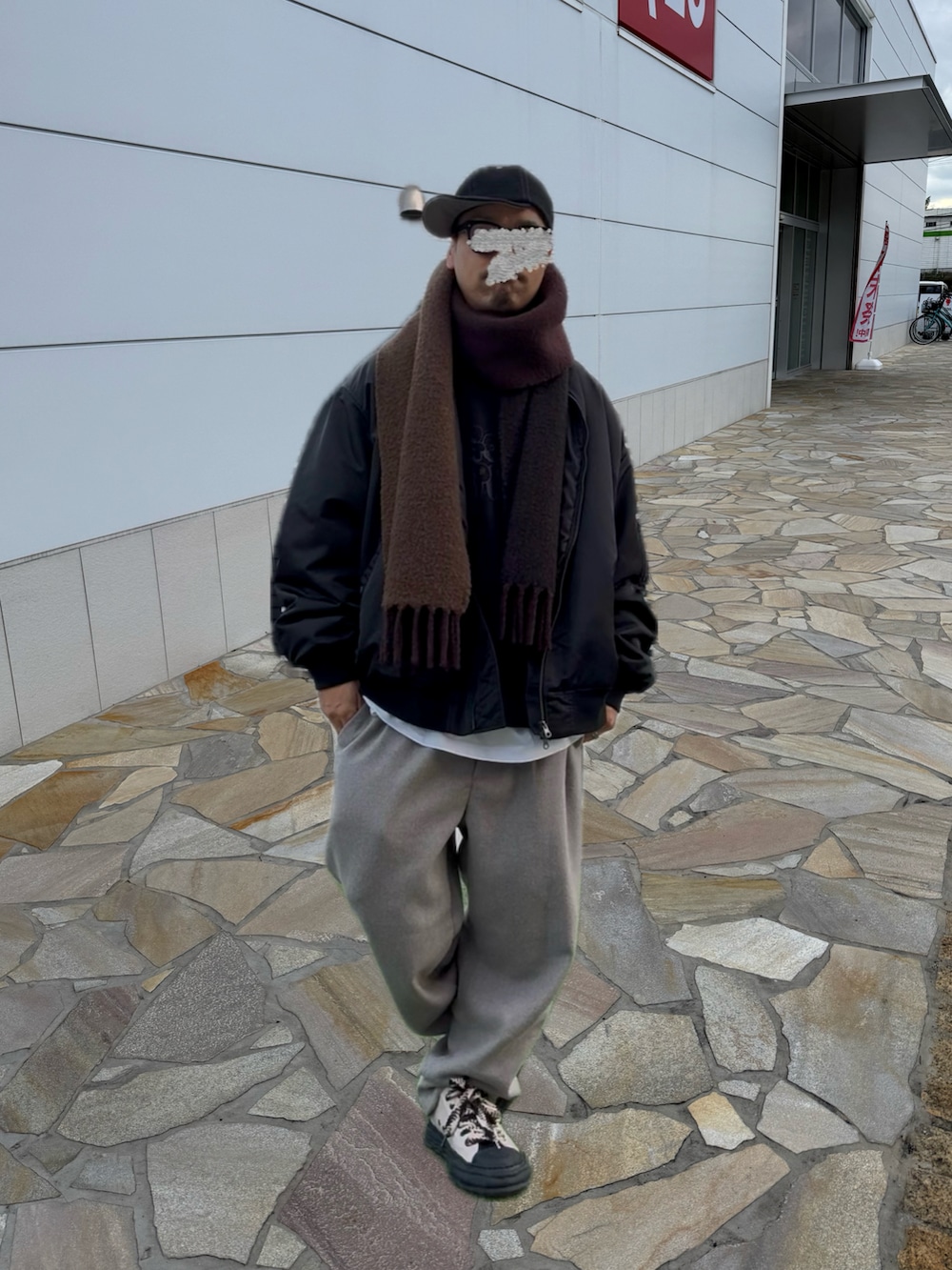 ベージュ系のスラックス、ベージュ系のスニーカー、ブラック系のスウェットを着用したメンズの冬コーディネートの3枚目の写真