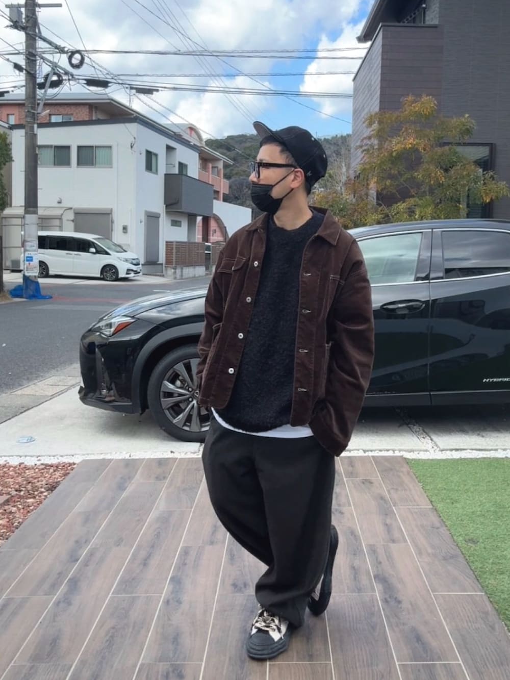 ブラウン系のブルゾン、ブラック系のニット/セーター、ブラウン系のスウェットパンツを着用したメンズの冬コーディネートの2枚目の写真
