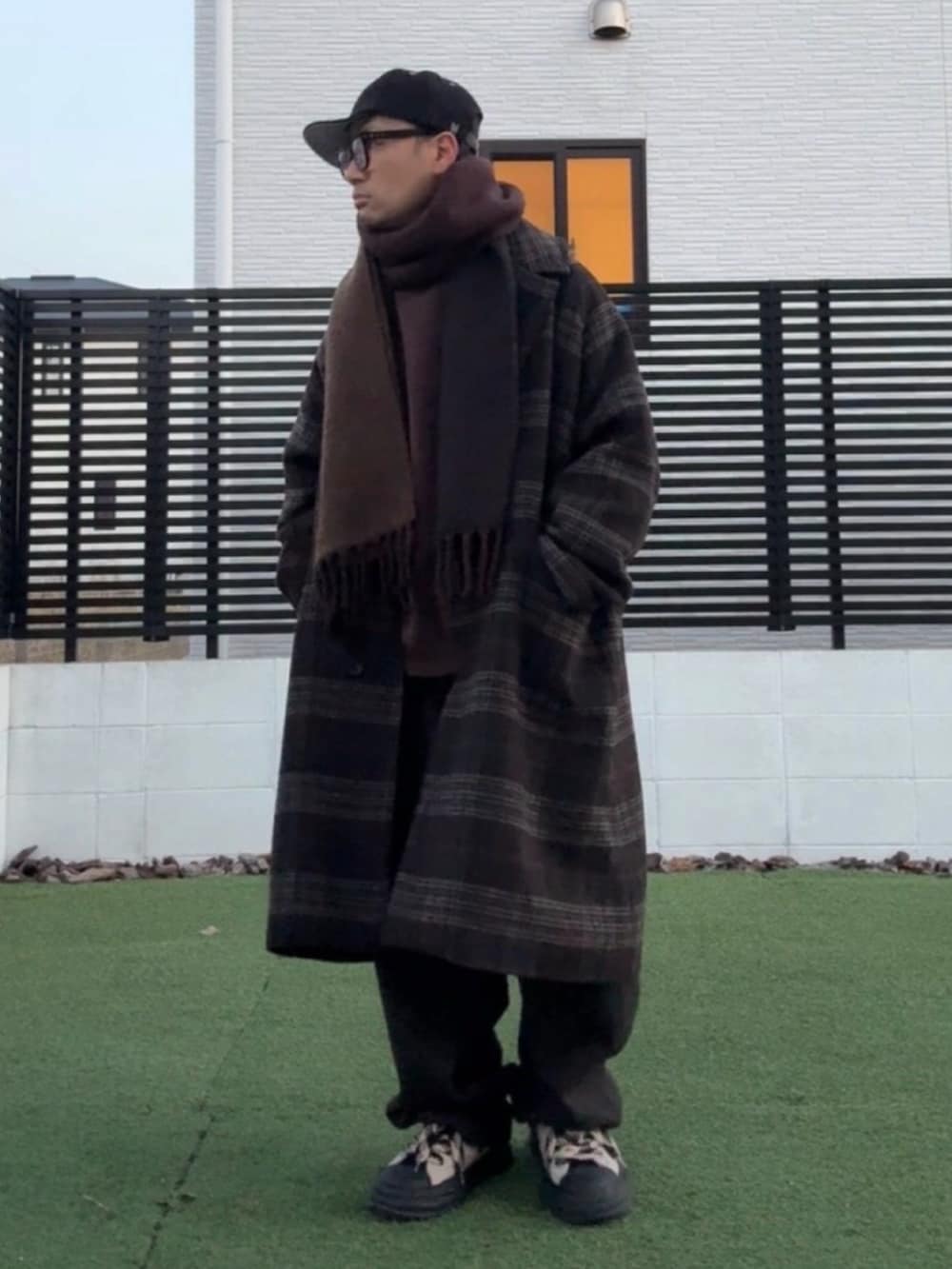 ブラウン系のスウェット、ブラウン系のチェスターコート、ブラウン系のスウェットパンツを着用したメンズの冬コーディネートの3枚目の写真