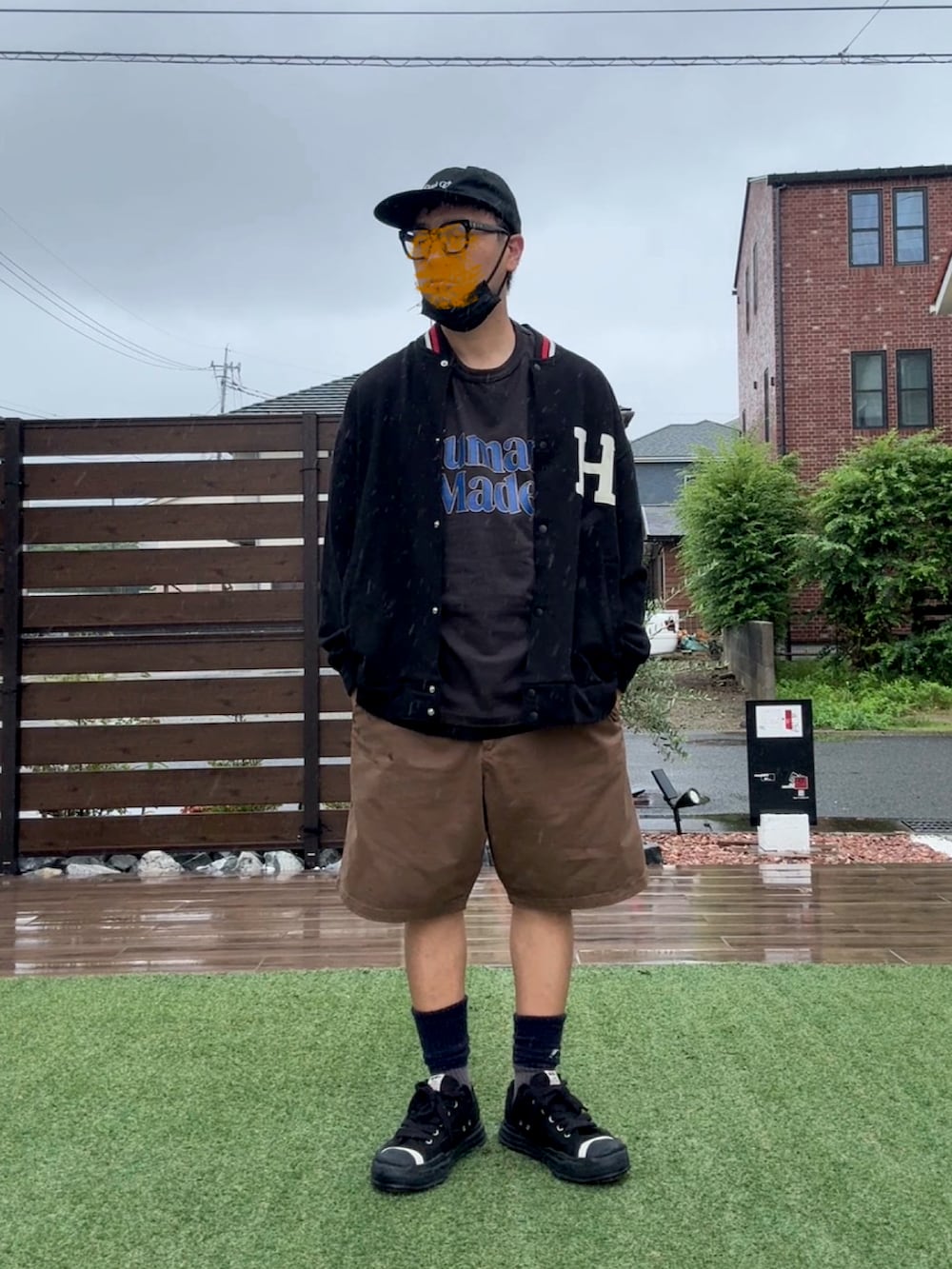 ブラック系のスニーカー、ブラック系のTシャツ/カットソー、ブラック系のスタジャンを着用したメンズの夏コーディネートの2枚目の写真