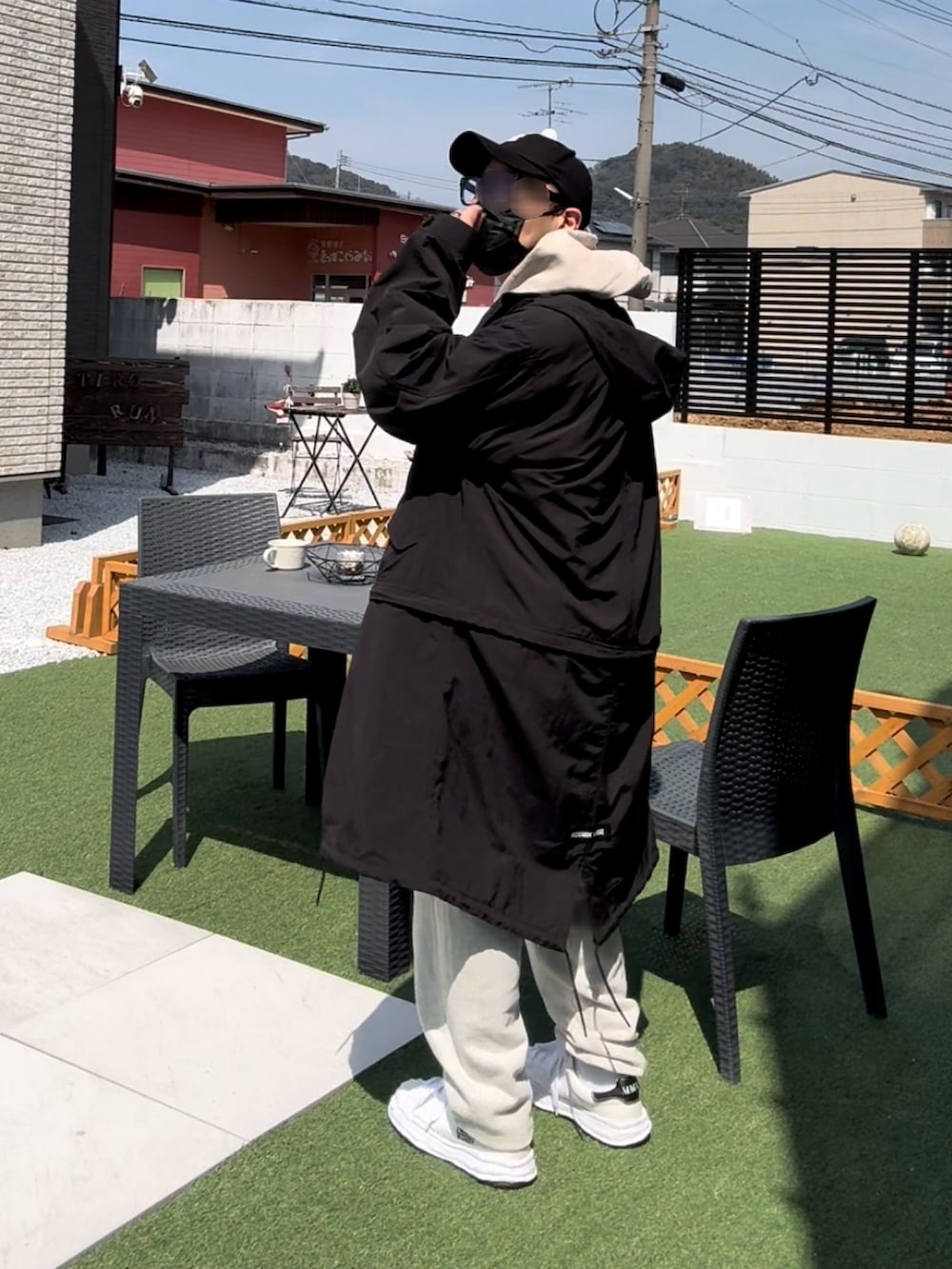 ブラック系のモッズコート、ベージュ系のパーカー、ホワイト系のスウェットパンツを着用したメンズの春コーディネートの3枚目の写真