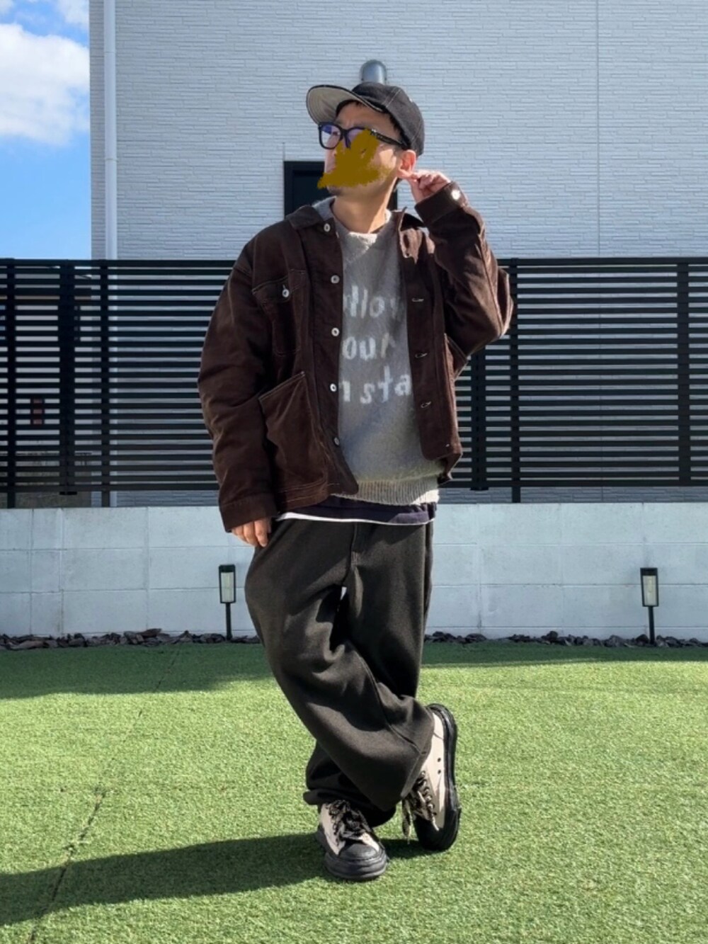 グレー系のニット/セーター、ブラウン系のブルゾン、ブラウン系のスウェットパンツを着用したメンズの秋コーディネートの2枚目の写真