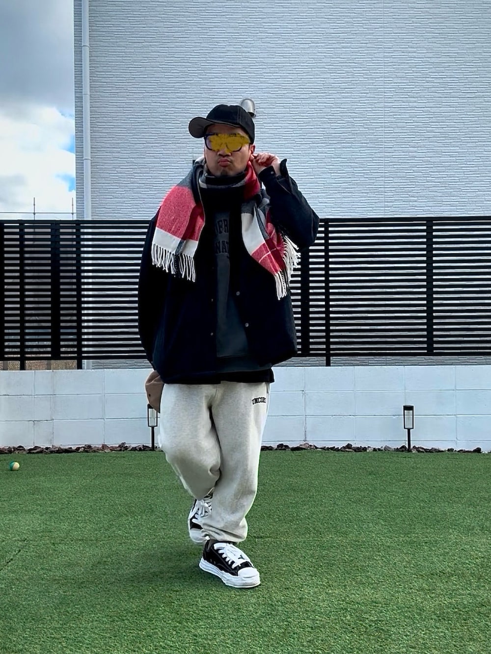 グレー系のスウェット、ベージュ系のスウェットパンツ、ブラック系のスニーカーを着用したメンズの冬コーディネートの2枚目の写真