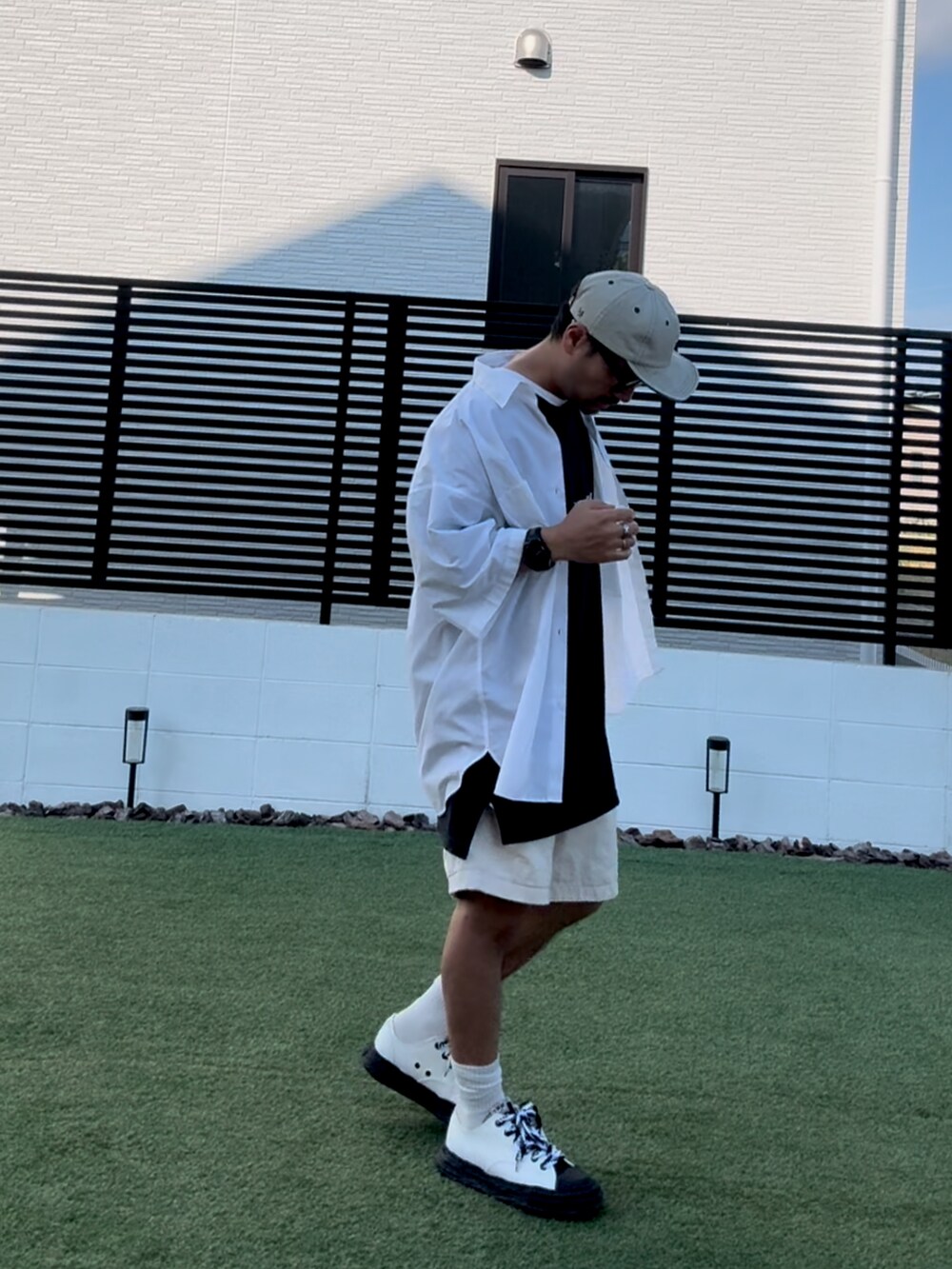 ブラック系のTシャツ/カットソー、ホワイト系のパンツ、ブラック系のスニーカーを着用したメンズの秋コーディネートの2枚目の写真