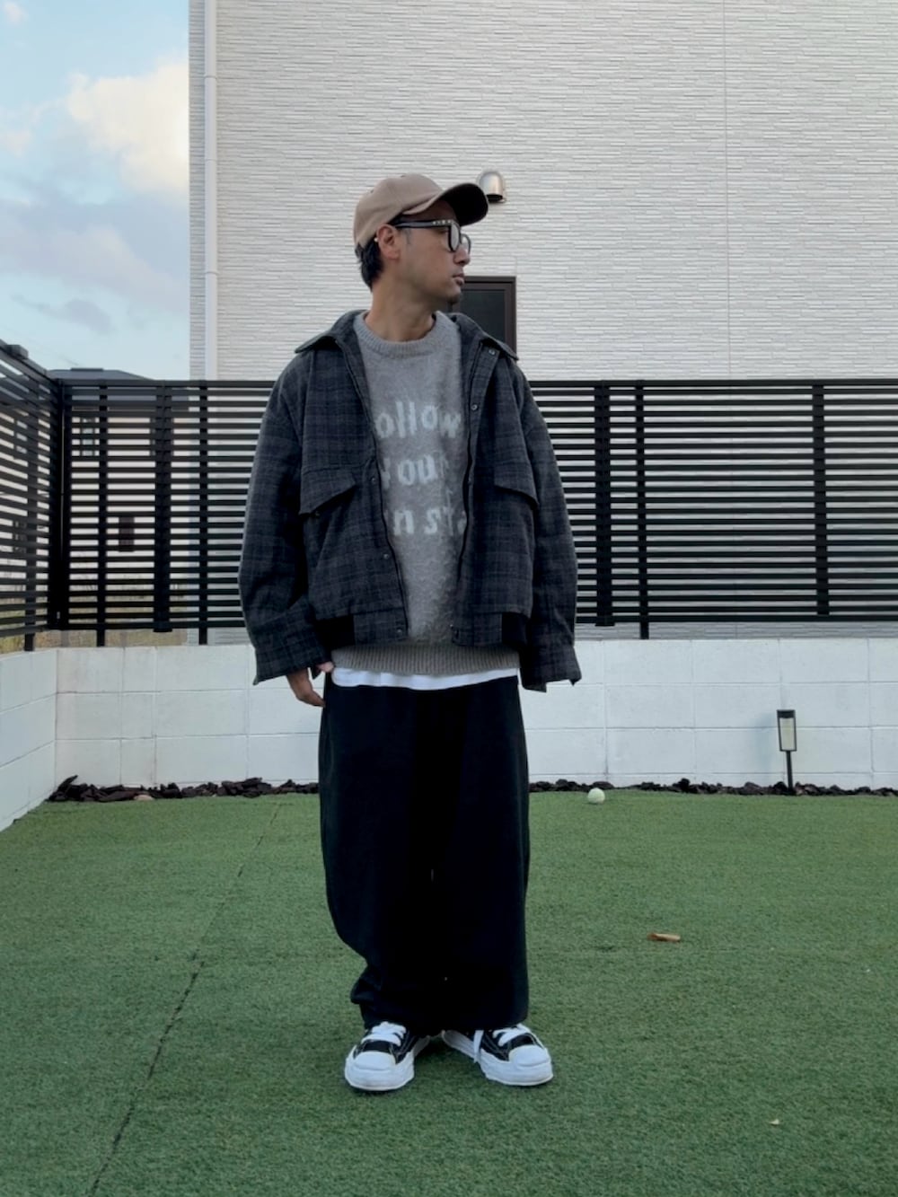 グレー系のニット/セーター、グレー系のブルゾン、ブラック系のスニーカーを着用したメンズの冬コーディネートの2枚目の写真