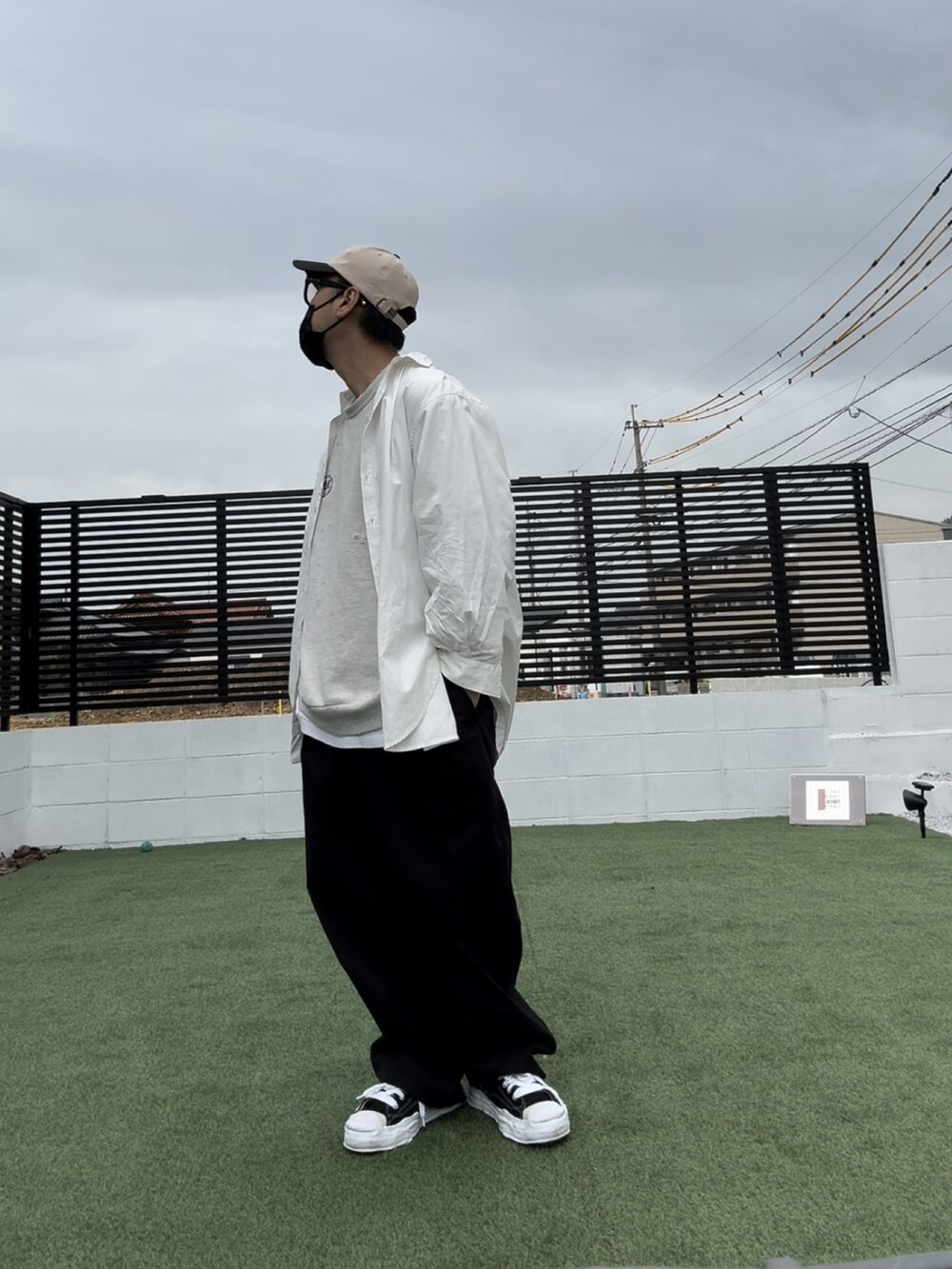 ホワイト系のスウェット、ブラック系のチノパンツ、ブラック系のスニーカーを着用したメンズの春コーディネートの3枚目の写真