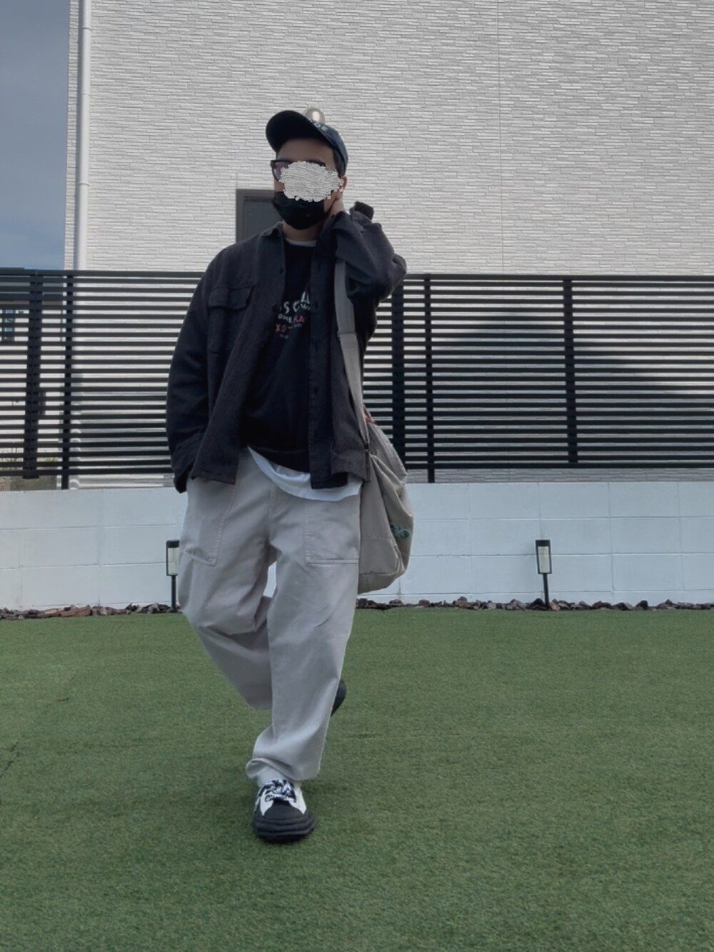 ベージュ系のその他パンツ、ブラック系のTシャツ/カットソー、ホワイト系のスニーカーを着用したメンズの春コーディネートの2枚目の写真