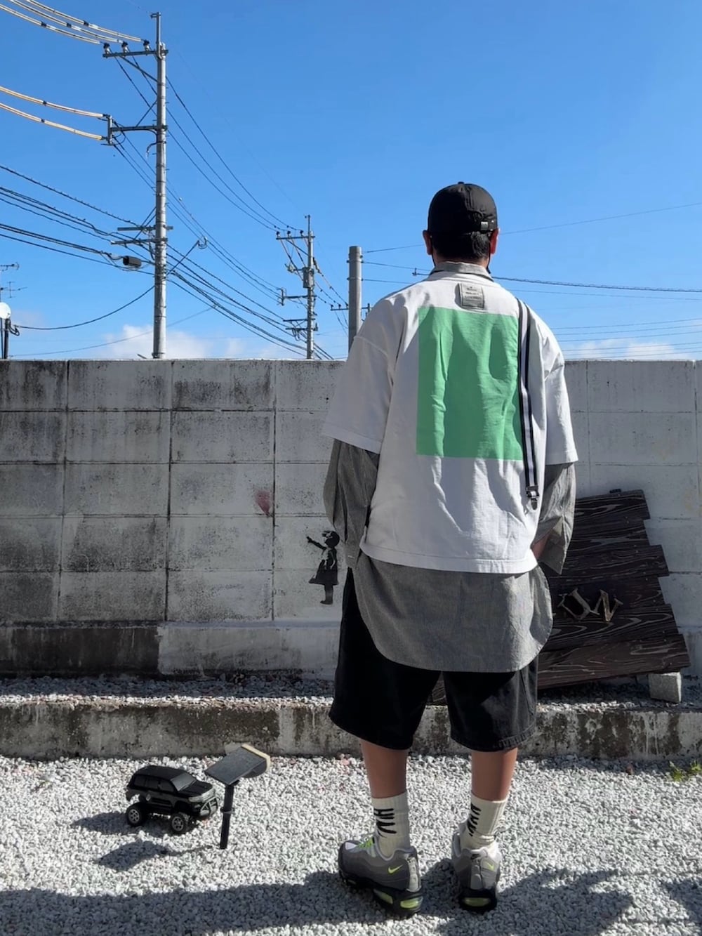 ブラック系のデニムパンツ、ホワイト系のTシャツ/カットソー、グレー系のスニーカーを着用したメンズの春コーディネートの4枚目の写真