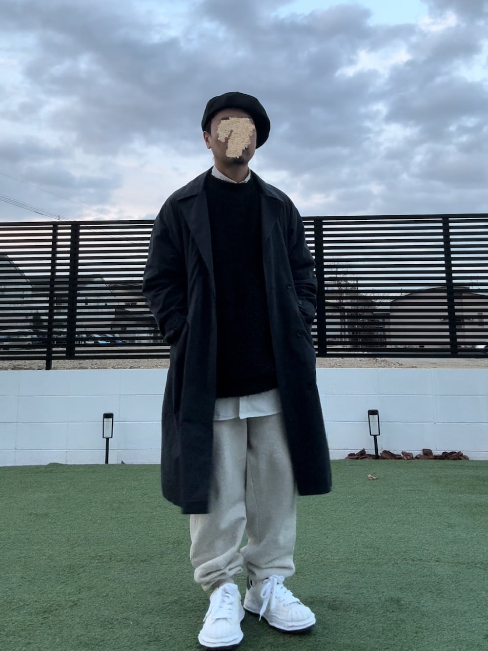 ベージュ系のスウェットパンツ、ホワイト系のスニーカー、ブルー系のチェスターコートを着用したメンズの冬コーディネートの2枚目の写真